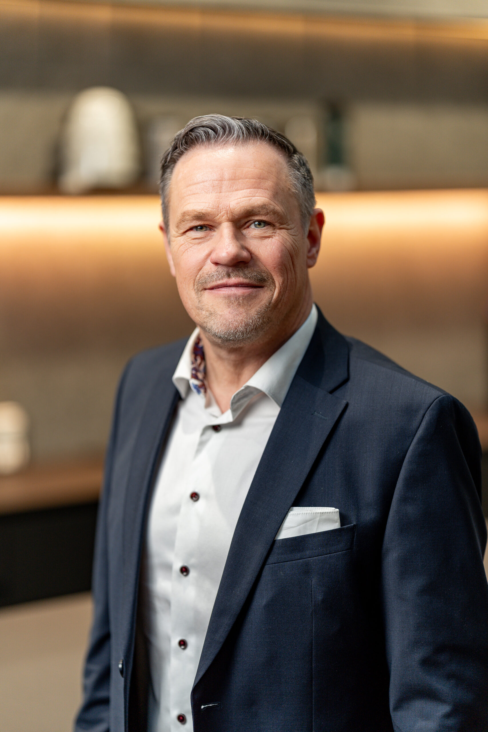 Businessportrait eines Mannes im dunkelblauen Sakko mit Einstecktuch, Julien Jones für Bremer Unternehmen