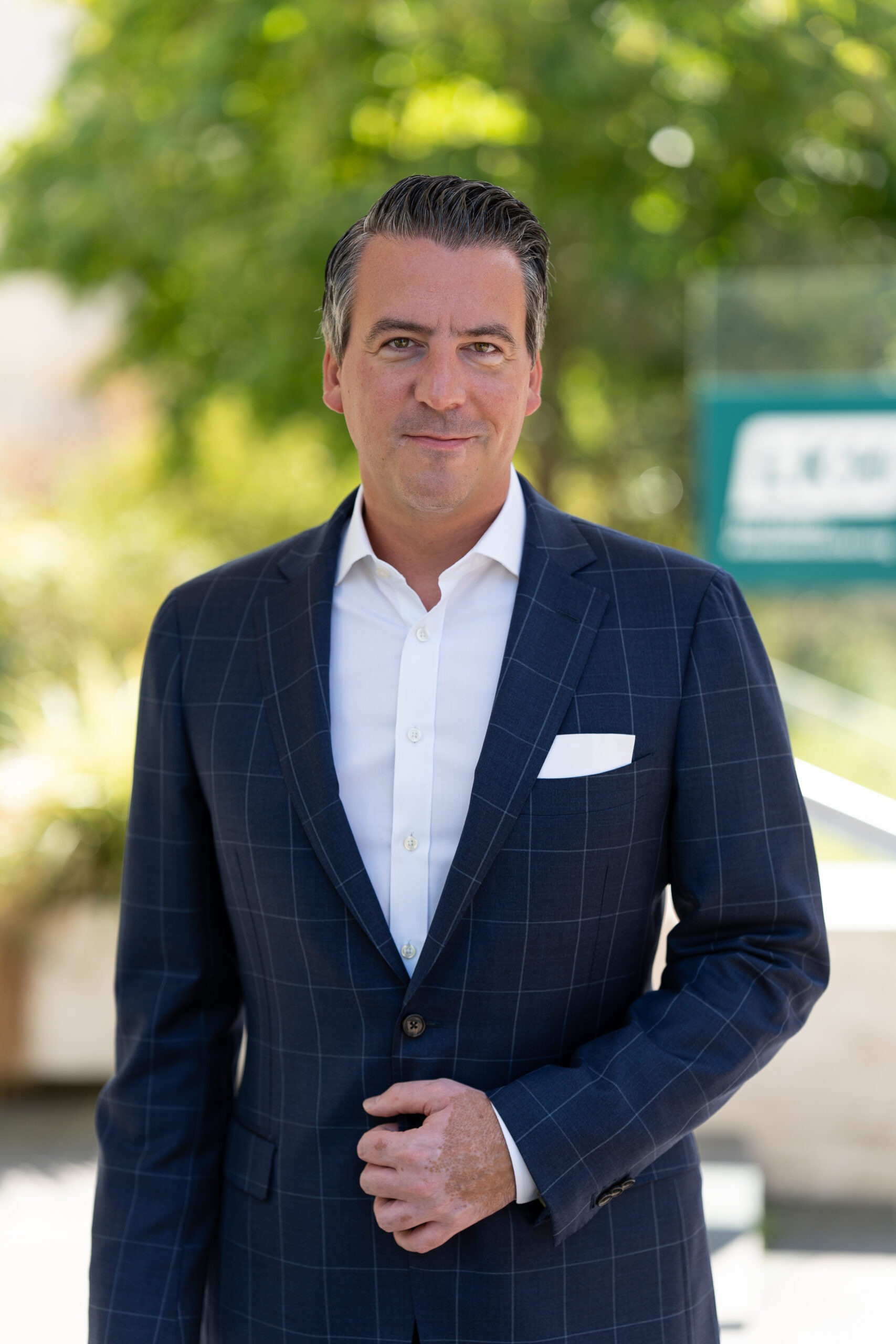 Vorstandsportrait einer Führungskraft im karierten Anzug vor grünem Hintergrund, Businessfotograf Hannover