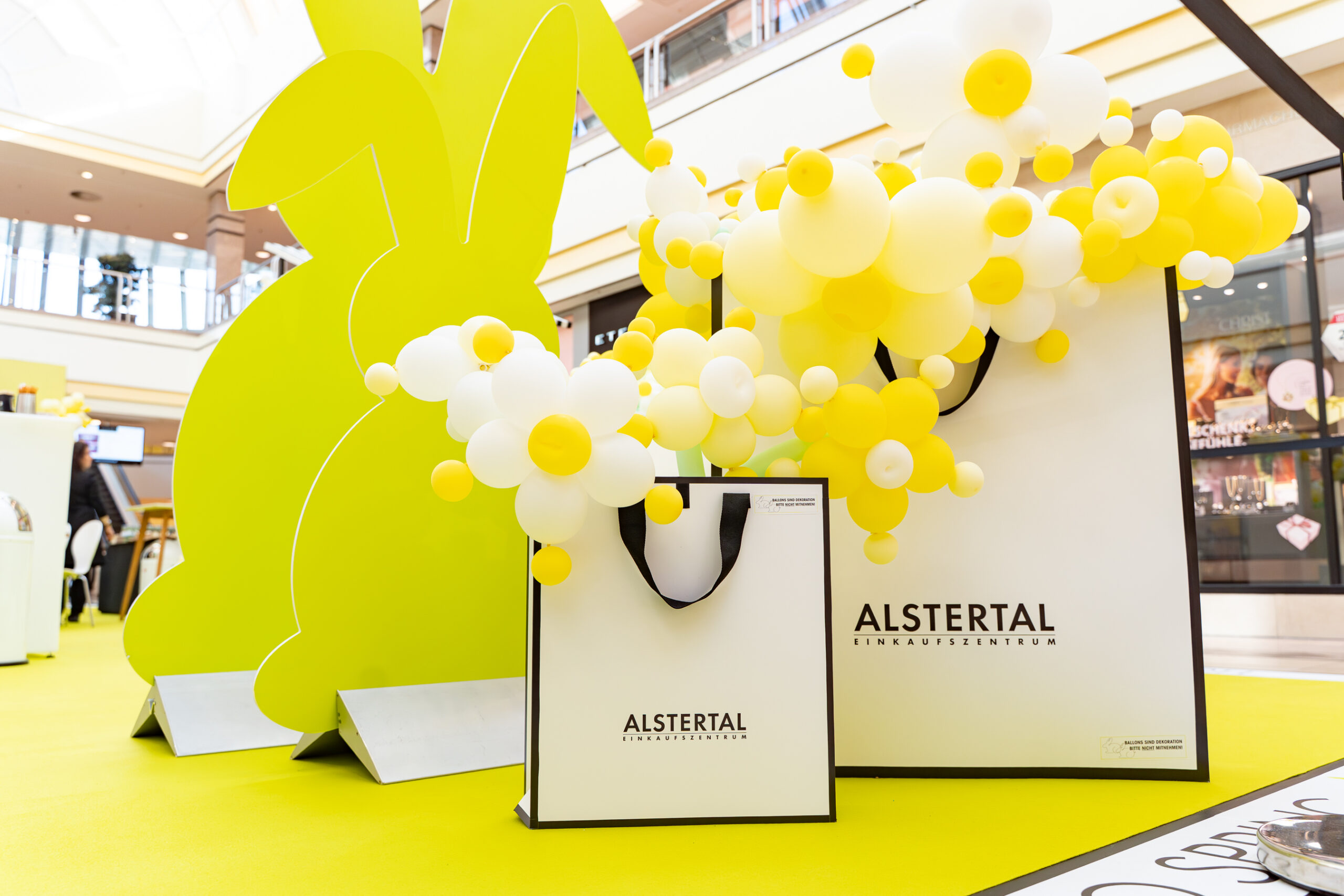 Gelbe Hasen-Deko, Ballons und Logo-Tüten bei einem Markenevent, Detailfotos für Bremer Brand Activations